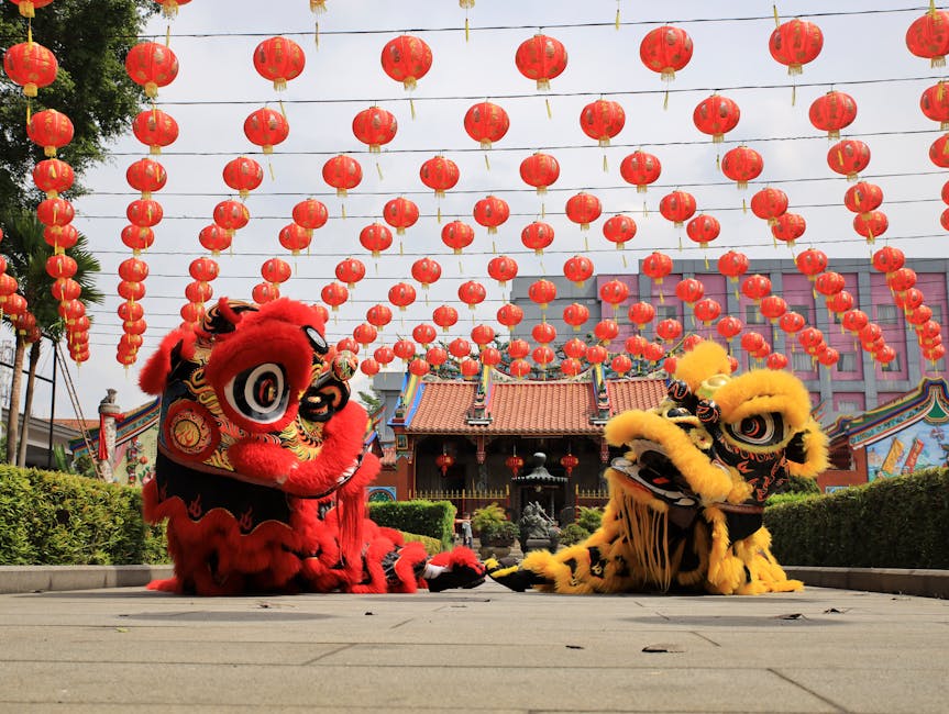 Energetic lion dance performance under red lanterns at Chinese New Year celebration in Bandung, Indonesia.
